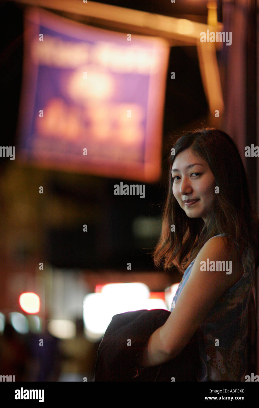 Retrato de mujer joven en frente de Blue Note Jazz Club, en la noche, Manhattan, Ciudad de Nueva York, Nueva York, EE.UU. Foto de stock