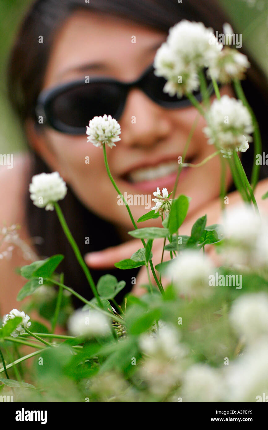 Mujer joven vistos a través de flores de trébol, New York City, New York, EE.UU. Foto de stock