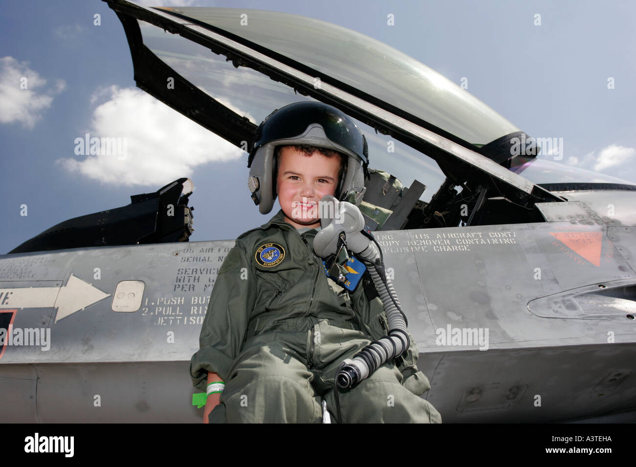 por ejemplo puerta encuesta Niño pequeño vestido con mono de piloto sentado junto a la cabina de un F16  Fotografía de stock - Alamy