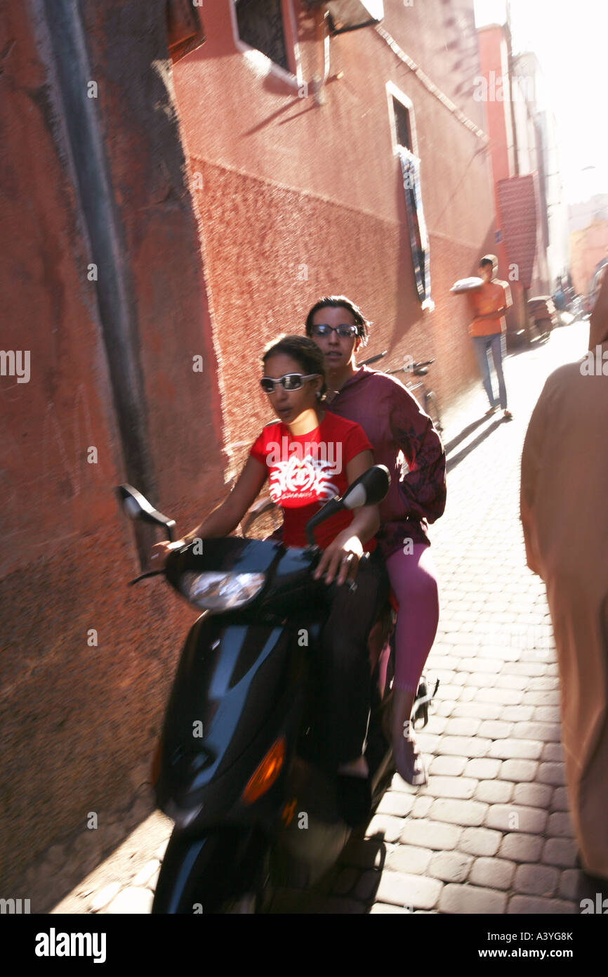 Dos niñas montando un scooter en Marakech Marruecos Foto de stock