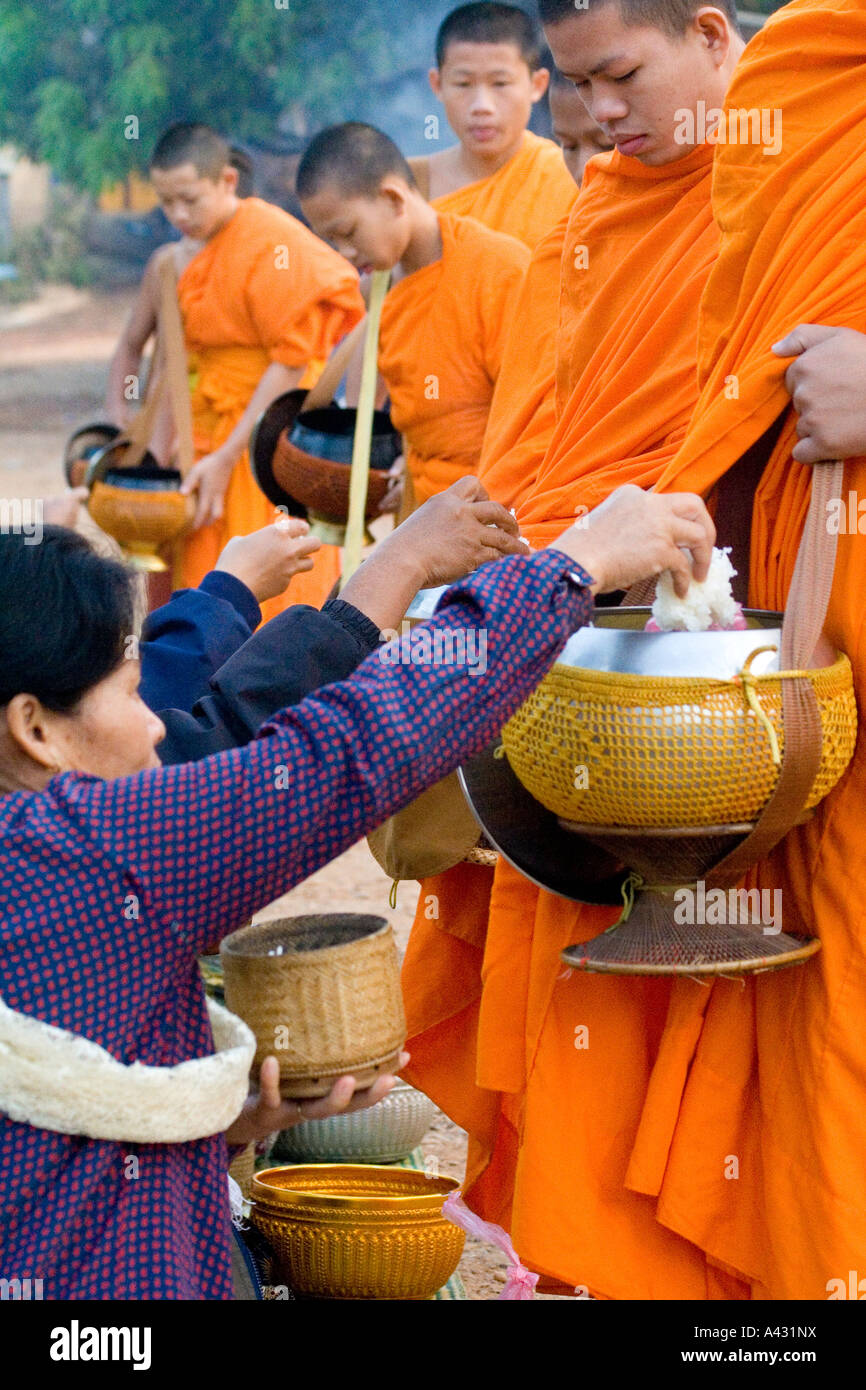 La gente local que ofrece comida a limosnas Vang Vieng Laos Foto de stock