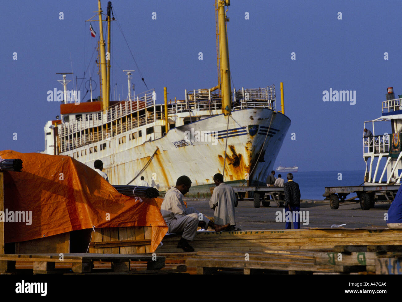 Los hombres esperan a la descarga de los buques en el puerto de la ciudad de Berbera autodeclarada país independiente de Somalilandia Foto de stock