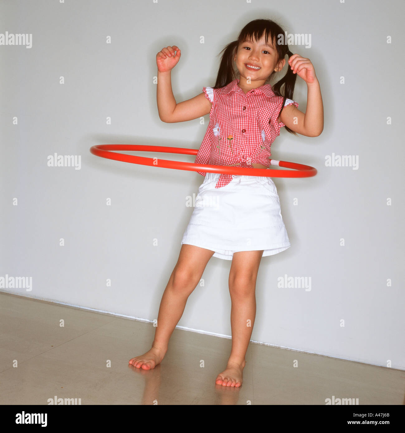 Niña jugando con el hula hoop en el exterior Fotografía de stock - Alamy