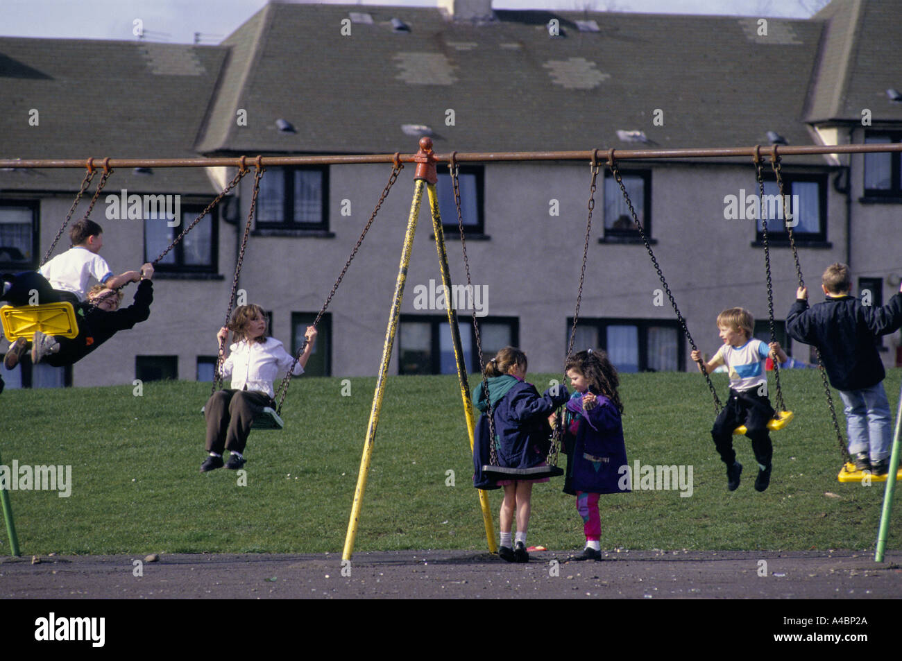 Motherwell, Escocia, marzo de 1992. Los niños juegan en los columpios. Ravenscraig acería cerrada en 1992 causando un desempleo masivo en la zona. Foto de stock