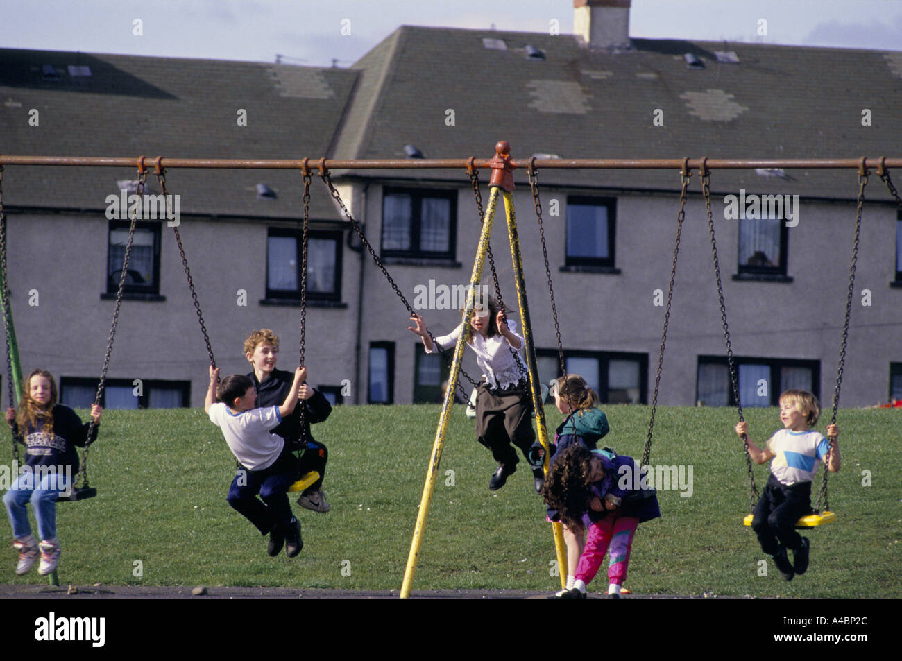 Motherwell, Escocia, marzo de 1992. Los niños juegan en los columpios. Ravenscraig acería cerrada en 1992 causando un desempleo masivo en la zona. Foto de stock