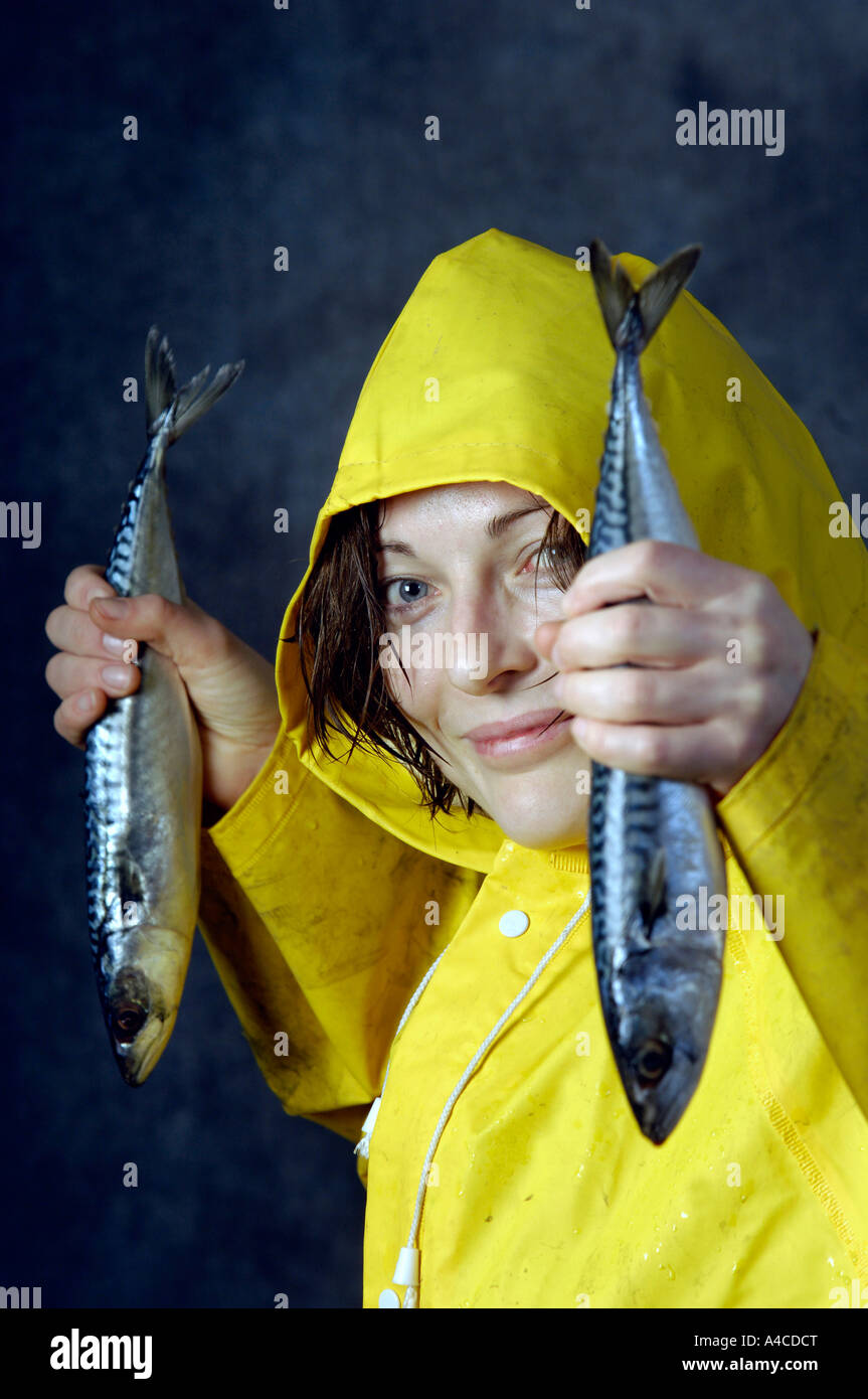 Una mujer en amarillo trajes de hule celebración pescado crudo Fotografía  de stock - Alamy