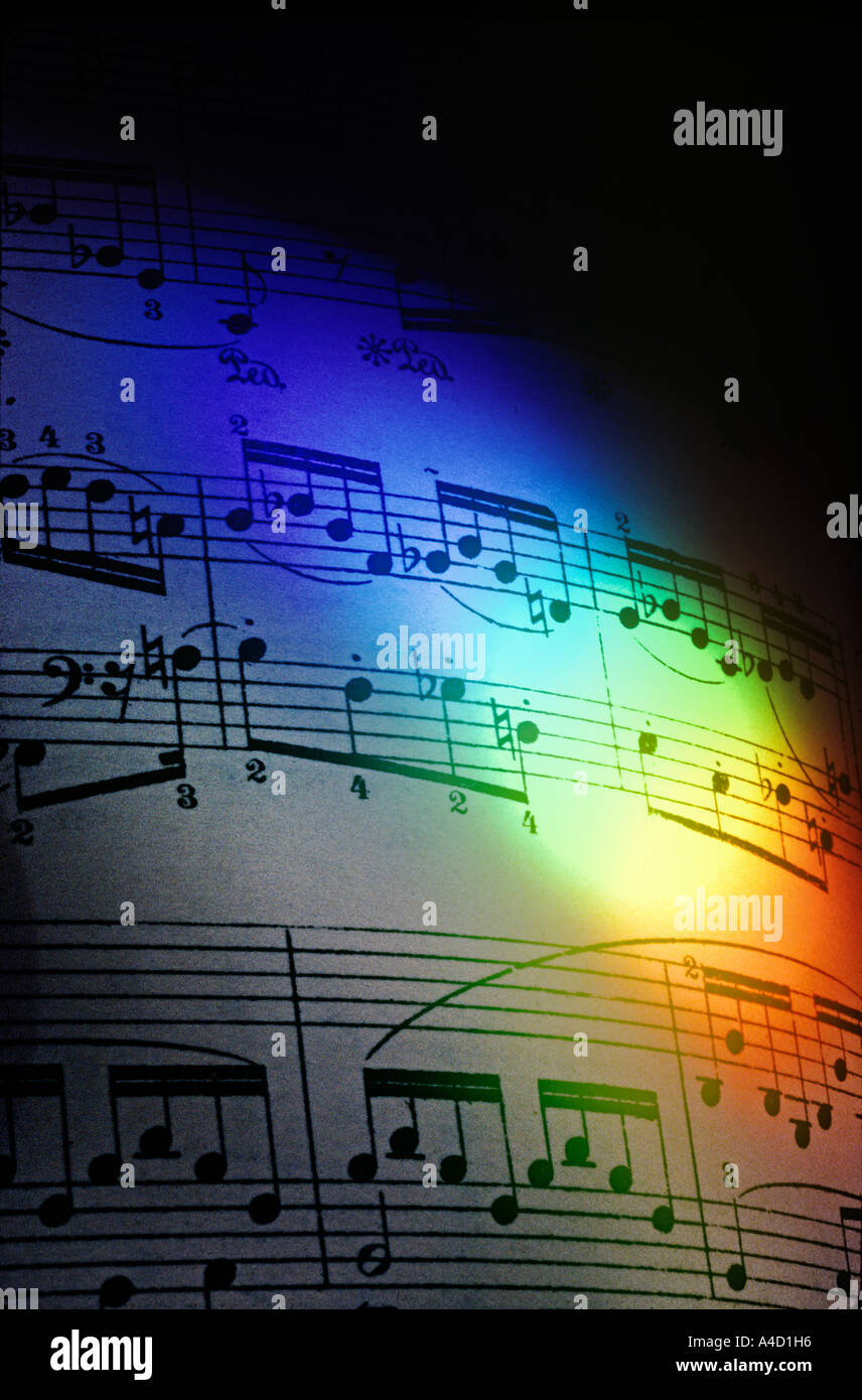 Un arco iris de colores emitidos por un prisma, se ilumina una página de música de piano de Chopin. Foto de stock