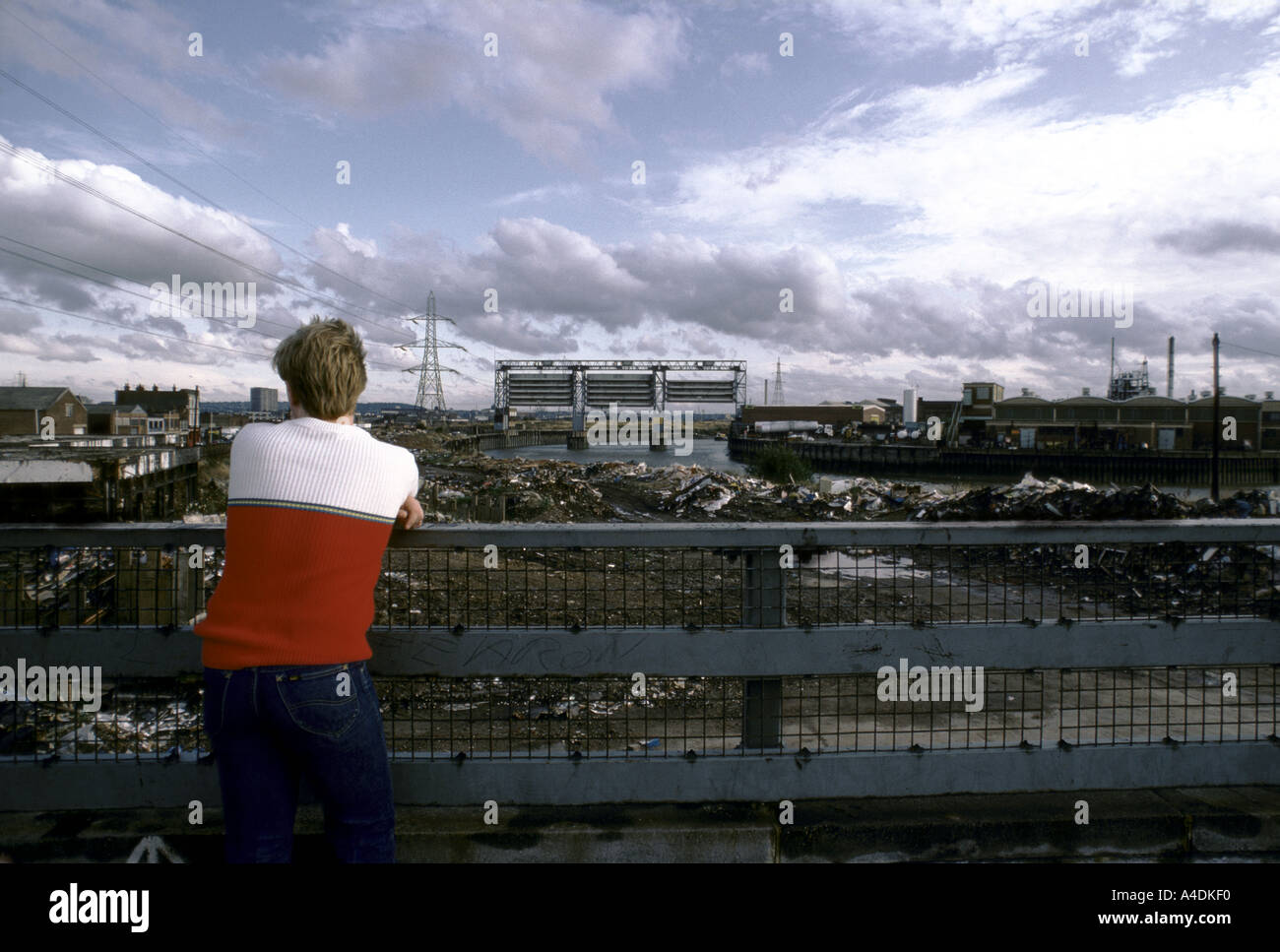 Una juventud desempleada mira la vista en Canning Town, East London, Reino Unido Foto de stock