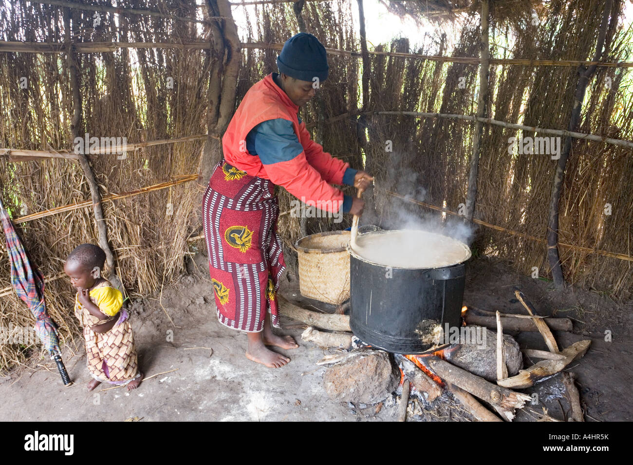 Haciendo phala (gachas de maíz) como parte del programa de alimentación del Proyecto José en la aldea de Makosana Malawi África Foto de stock