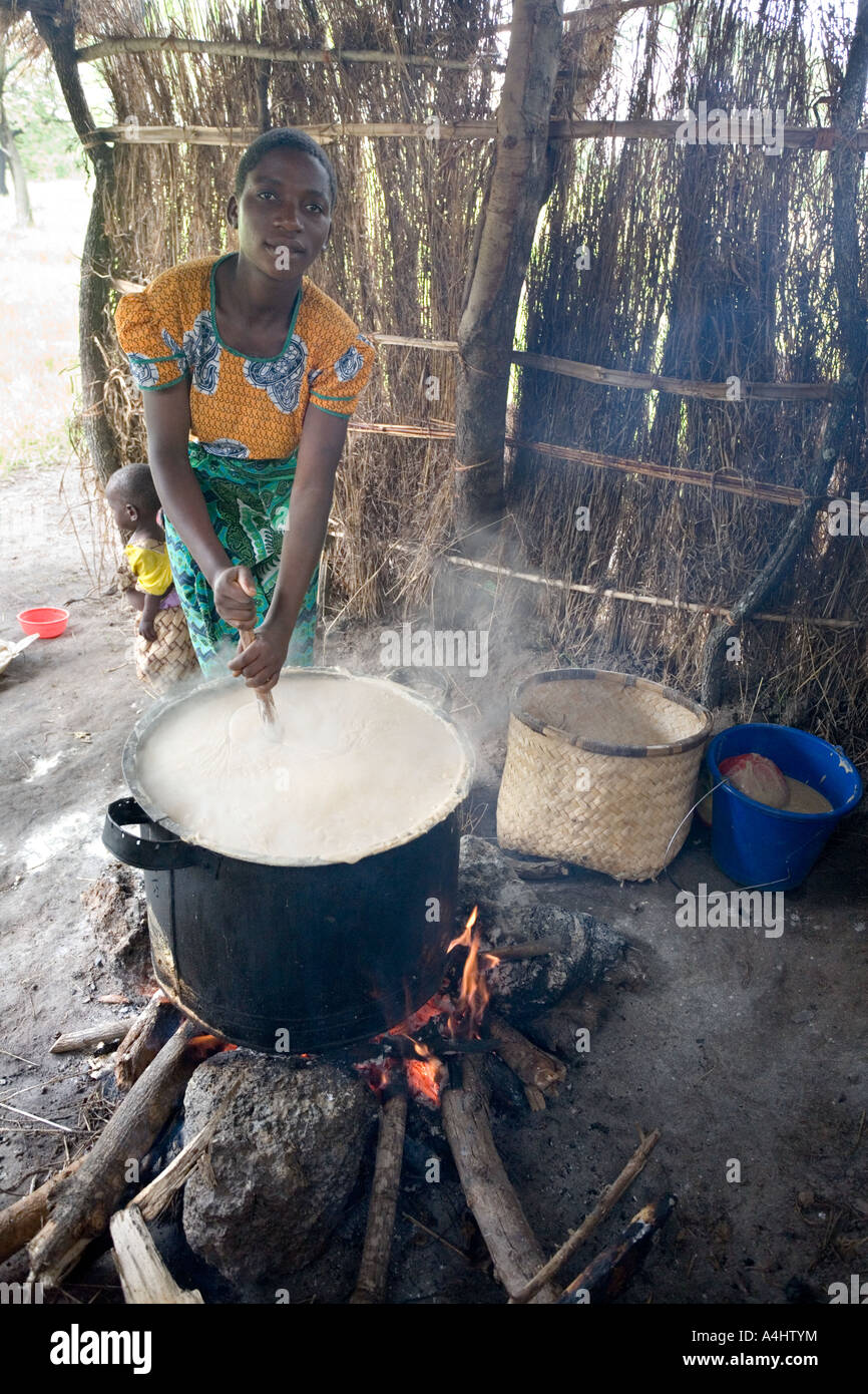 Haciendo phala (gachas de maíz) como parte del programa de alimentación del Proyecto José en la aldea de Makosana Malawi África Foto de stock