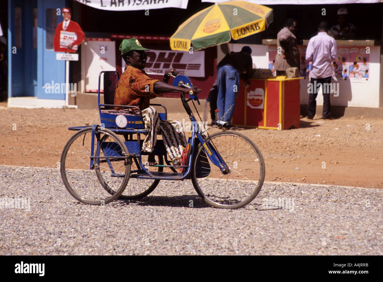 Víctima de la poliomielitis en silla de ruedas, Ouagadougou, Burkina Faso, África occidental. Foto de stock