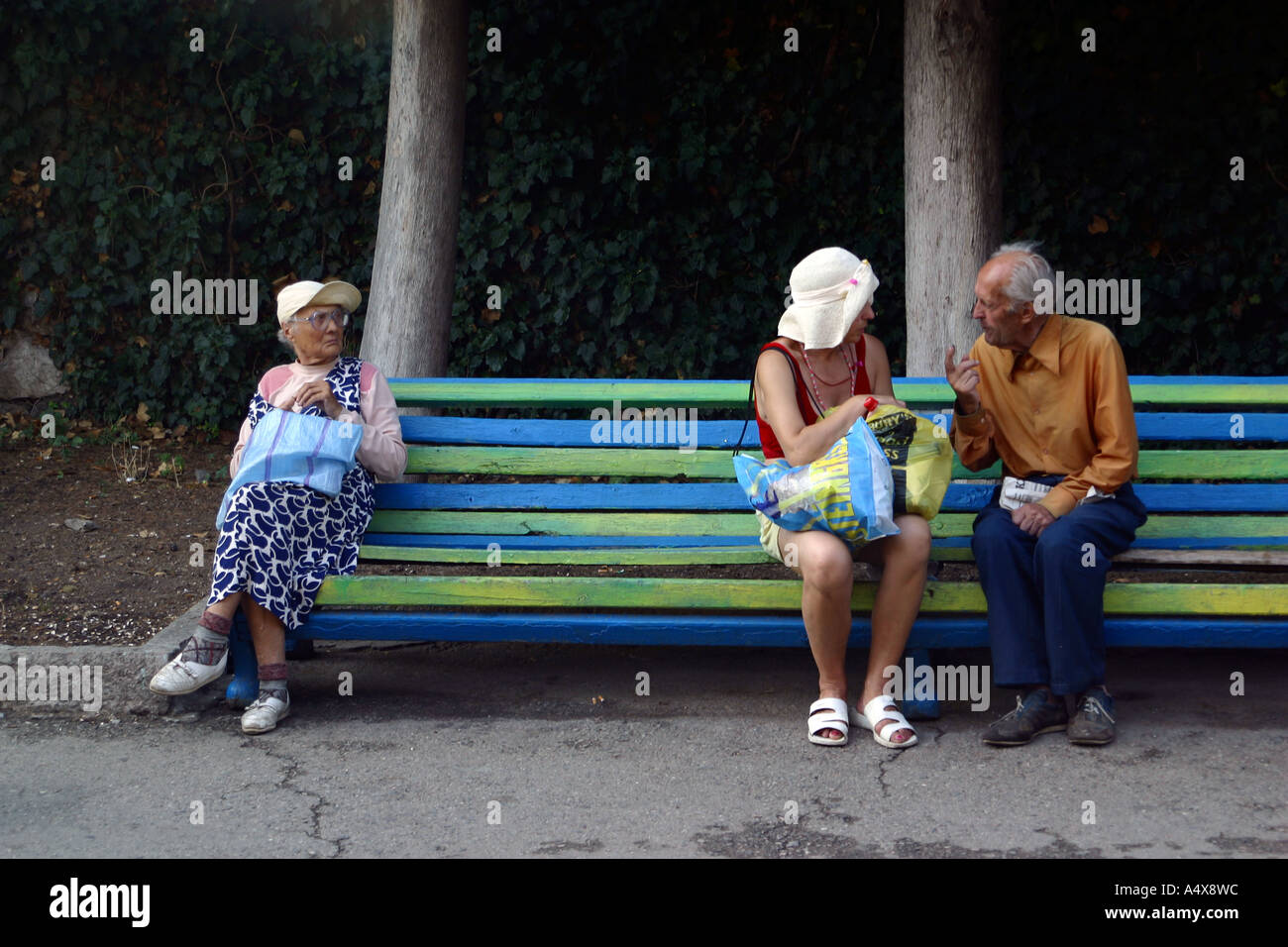 Ucrania, Crimea, 2002. Mujer escuchando la conversación de una pareja de ancianos Foto de stock