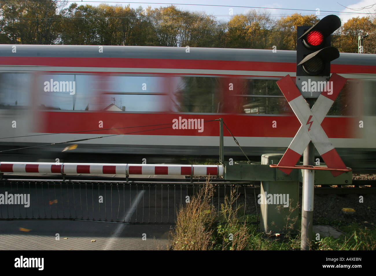 Un tren pasa aclosed gate en el cruce ferroviario Foto de stock