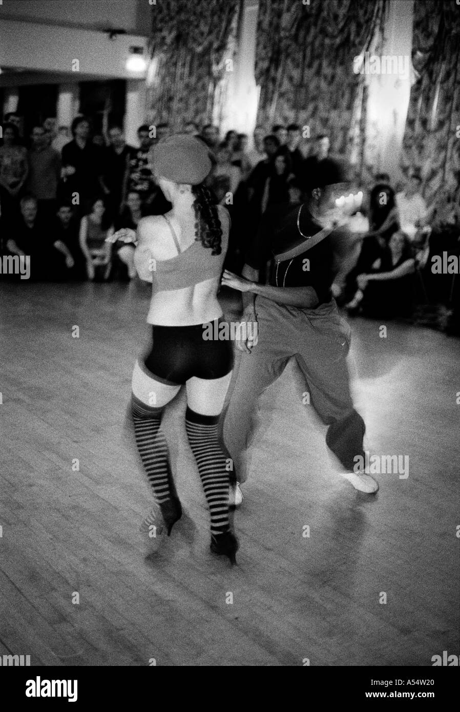 En blanco y negro de una pareja realizando una salsa cabaret con audiencia en el fondo Foto de stock