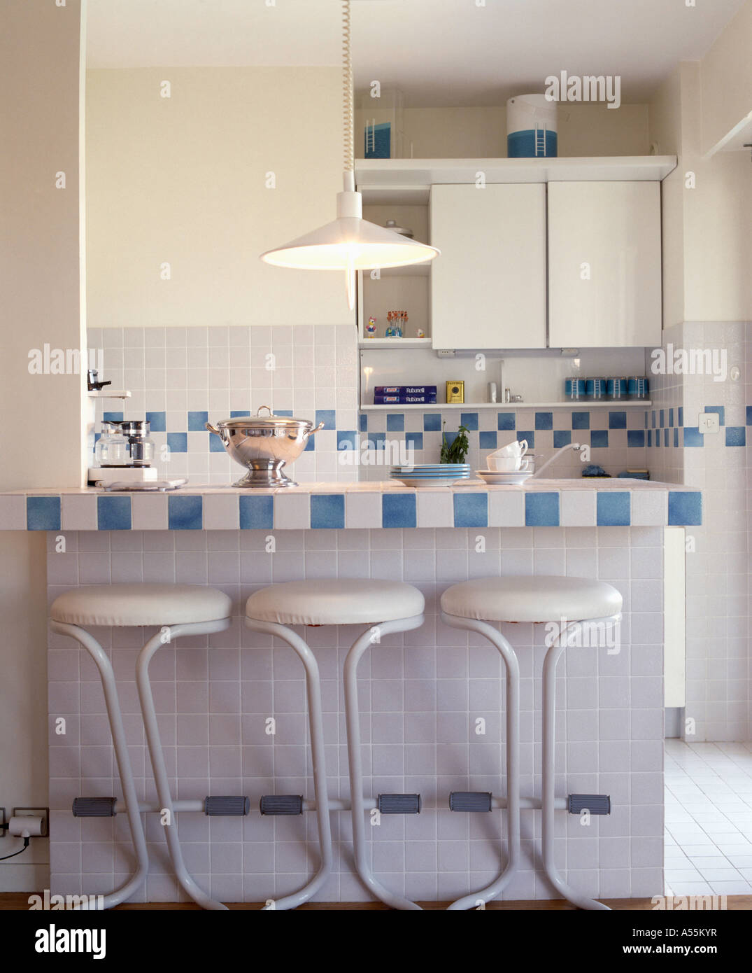 Cocina moderna con heces de color blanco en la barra de desayuno, con azulejos  de color blanco y azul Fotografía de stock - Alamy