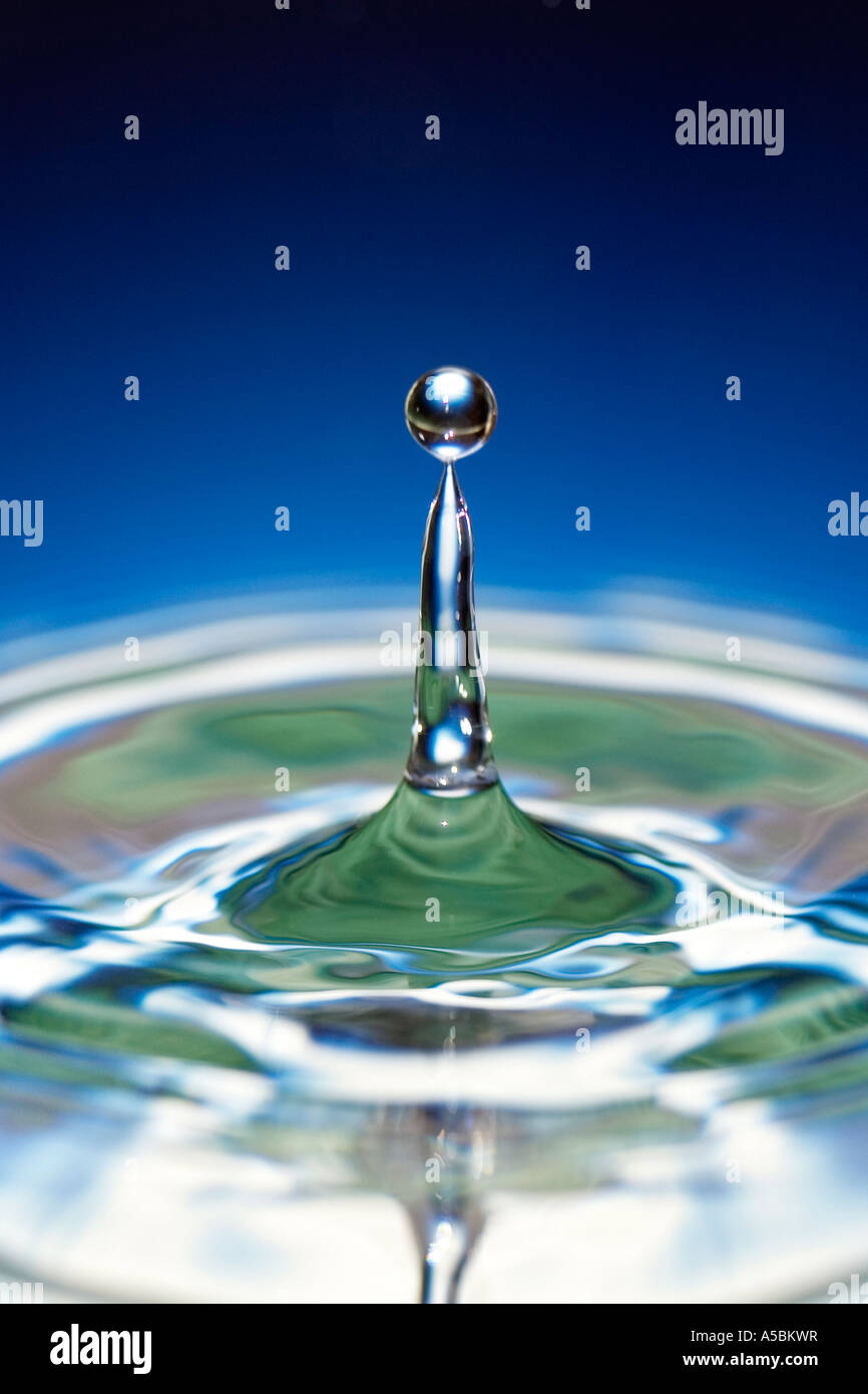 Gotas de agua sobre la superficie de espejo de agua de degradado de color azul. Agua sobre un plato con espejo refleja el color Foto de stock