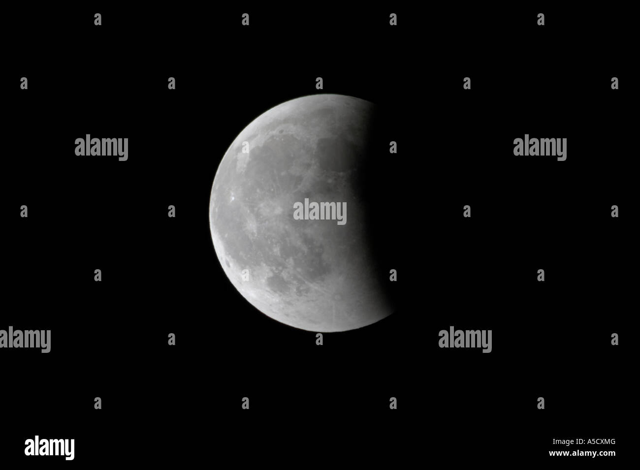 Luna casi surgido de las masas al final de la sombra de un eclipse total de luna visto desde Irlanda del Norte en marzo de 2007 Foto de stock