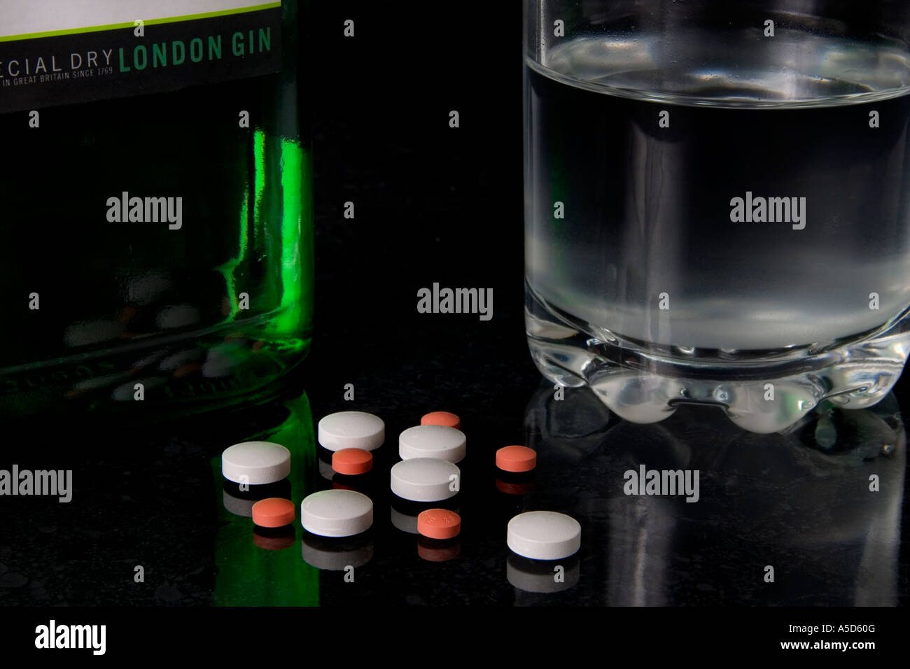Secadora de gin con una carga de píldoras para simbolizar la adicción y suicidio overdos o quizá sólo una prudente combinación Foto de stock