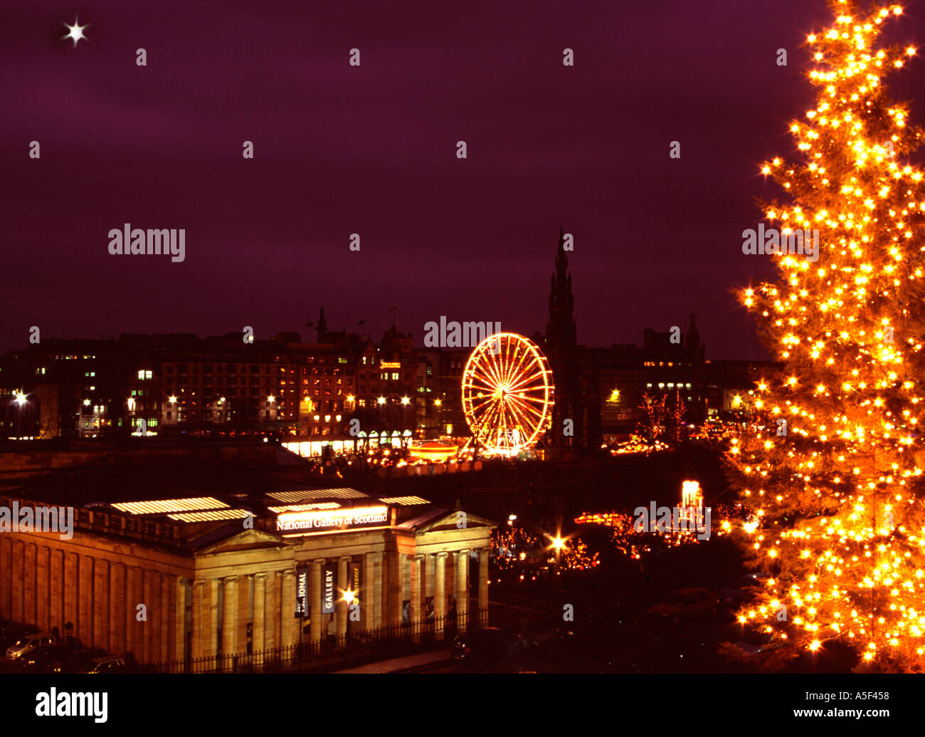 Árbol de Navidad de la ciudad de Edimburgo en el Montículo con la galería de arte y Princes Street, justo en el fondo además de estrella a la izquierda Foto de stock