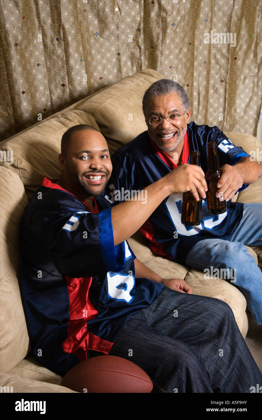 Retrato de un afroamericano, padre e hijo, brindando con cerveza en el sofá  Fotografía de stock - Alamy