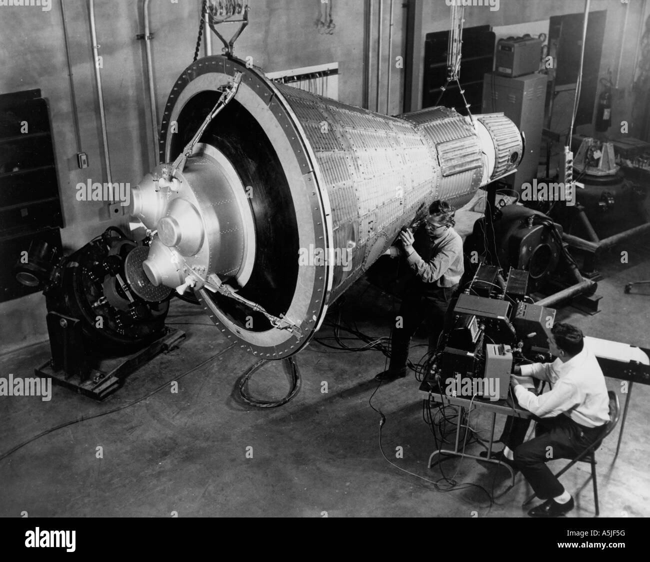 Ingenieros inspeccionar y probar una cápsula espacial Mercurio repetitivo. 01/01/1960 Foto de stock