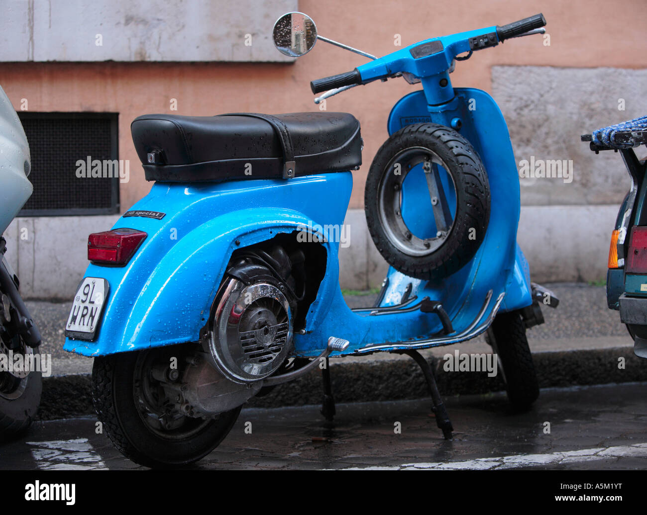 Azul pálido ciclomotor estacionado en una calle trasera en Roma Italia Foto de stock