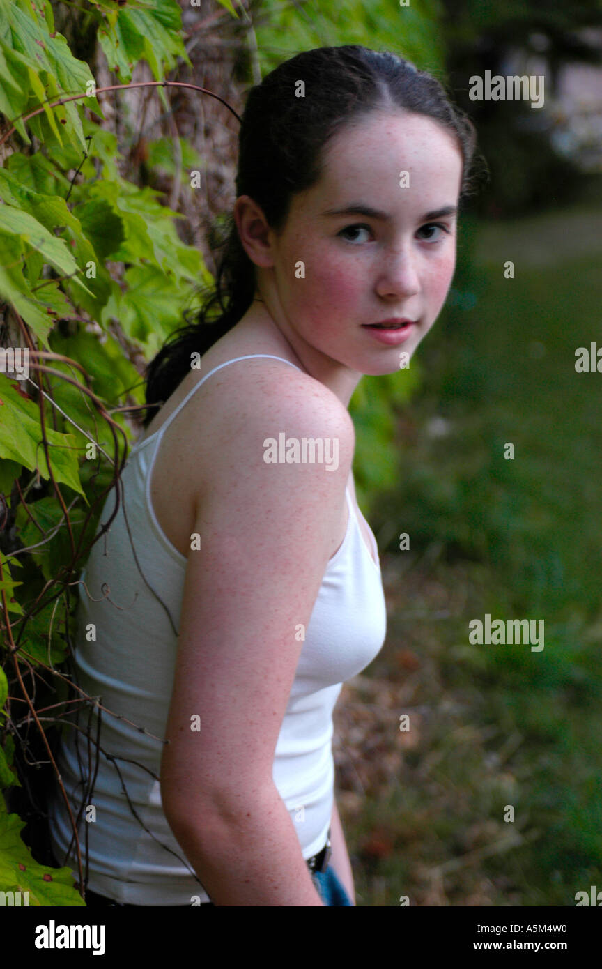 Una niña de 13 años con pelo marrón y pecas está apoyado contra una pared  cubierta de vid y mirando por encima del hombro en el visor Fotografía de  stock - Alamy
