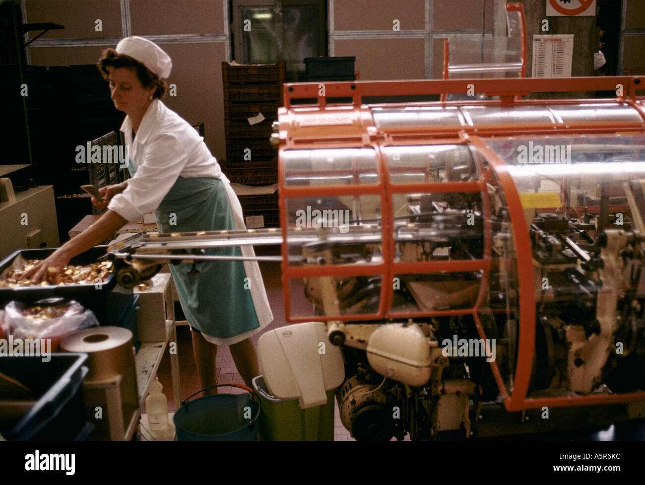 Mujer trabajando en la línea de producción de embalaje maquinaria CAFFAREL CHOCOLATES LUSERNA SAN GIOVANNI Foto de stock