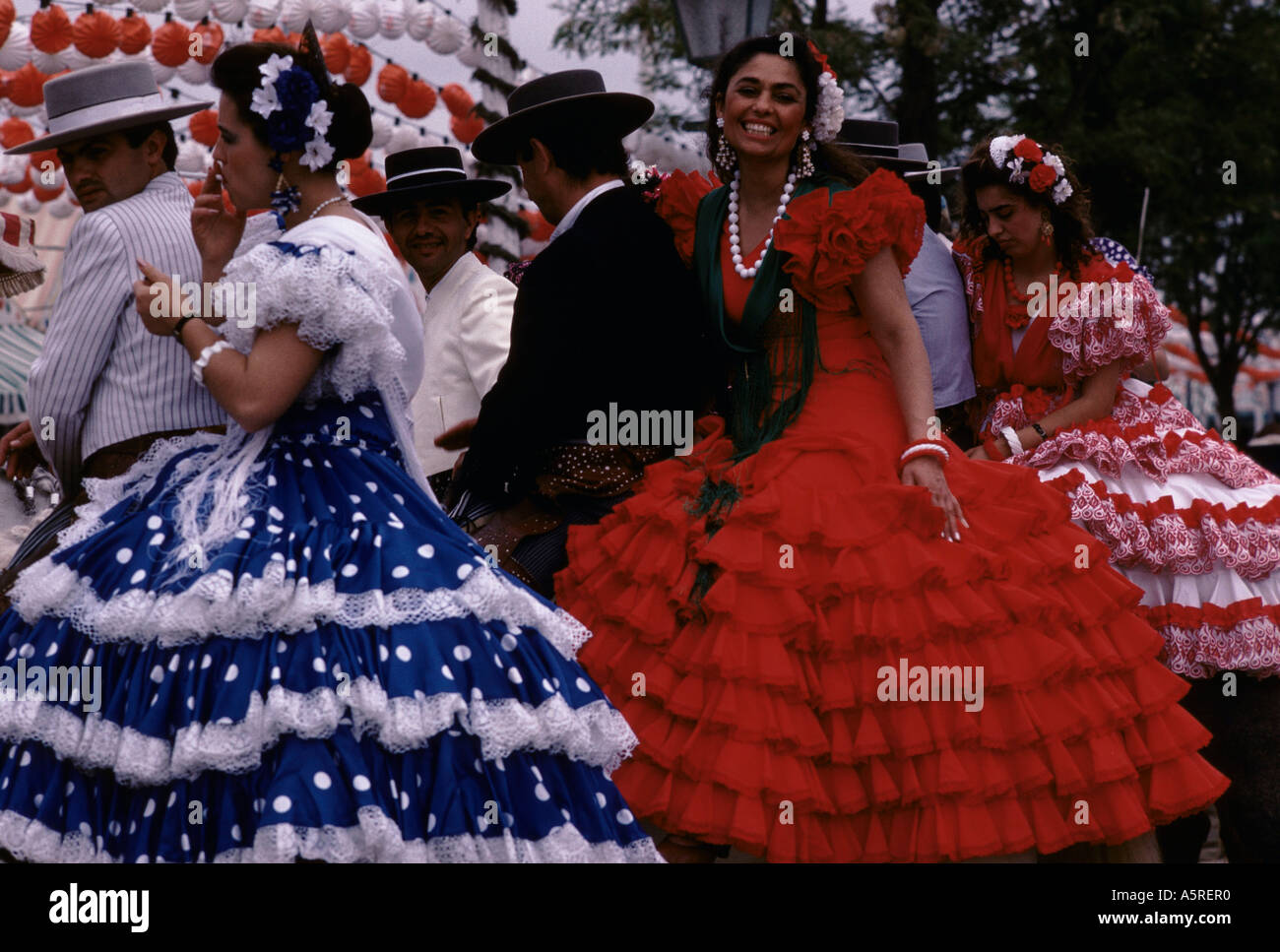 Feria de Sevilla, los hombres en un estilo tradicional español caballo ropa mujer en trajes de flamenca en montar dos caballos, España Fotografía de stock - Alamy