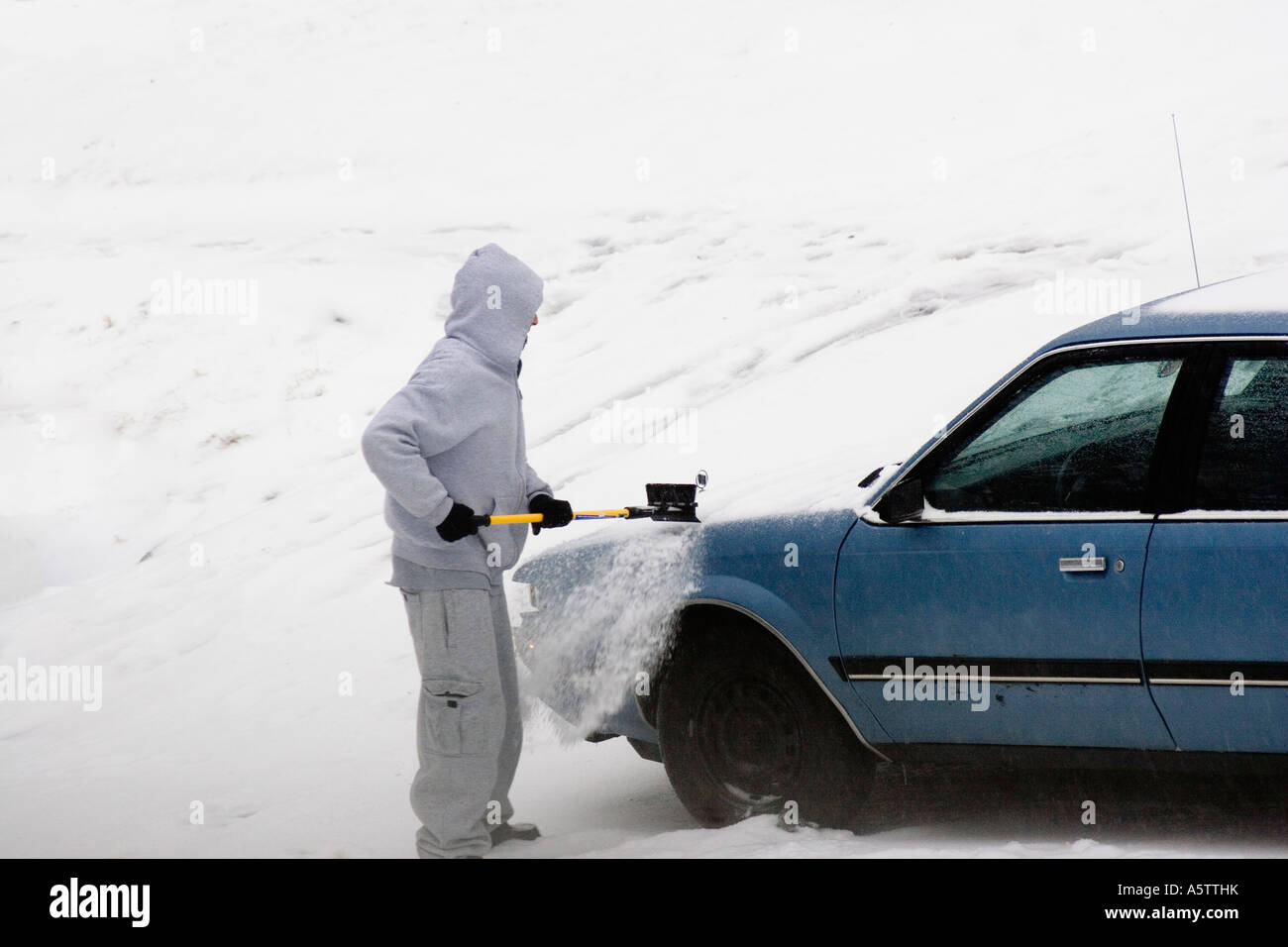 Hombre de nieve de cepillado apagado auto en una ventisca, Connecticut, Estados Unidos Foto de stock