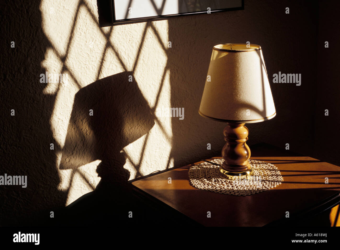 Fuerte sombra proyectada en la pared desde el final de la tarde la luz del sol a través de la ventana de vidrio emplomado Foto de stock
