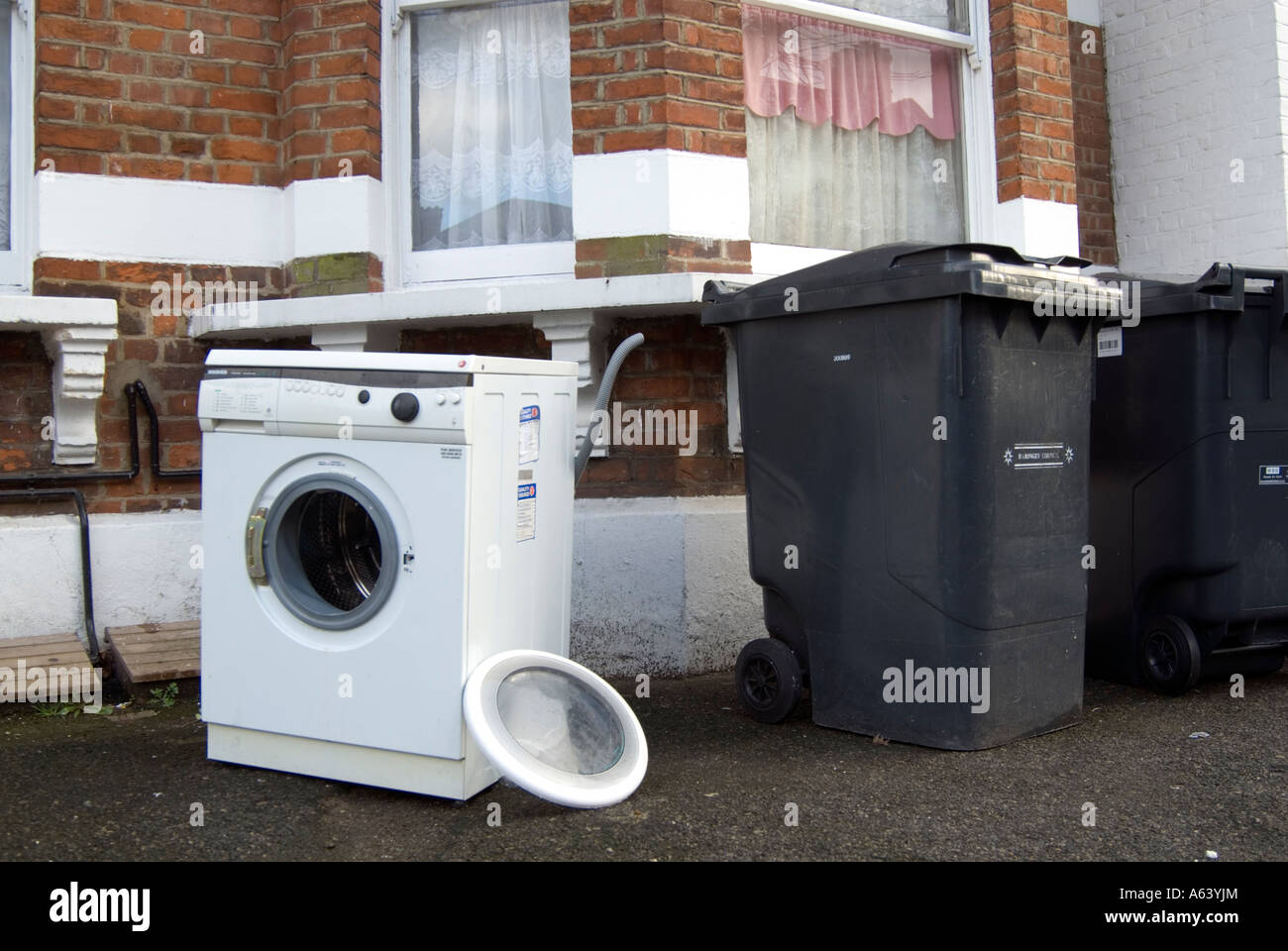 Descartan vieja lavadora sobre pavimento fuera House, Londres, Inglaterra,  Reino Unido Fotografía de stock - Alamy