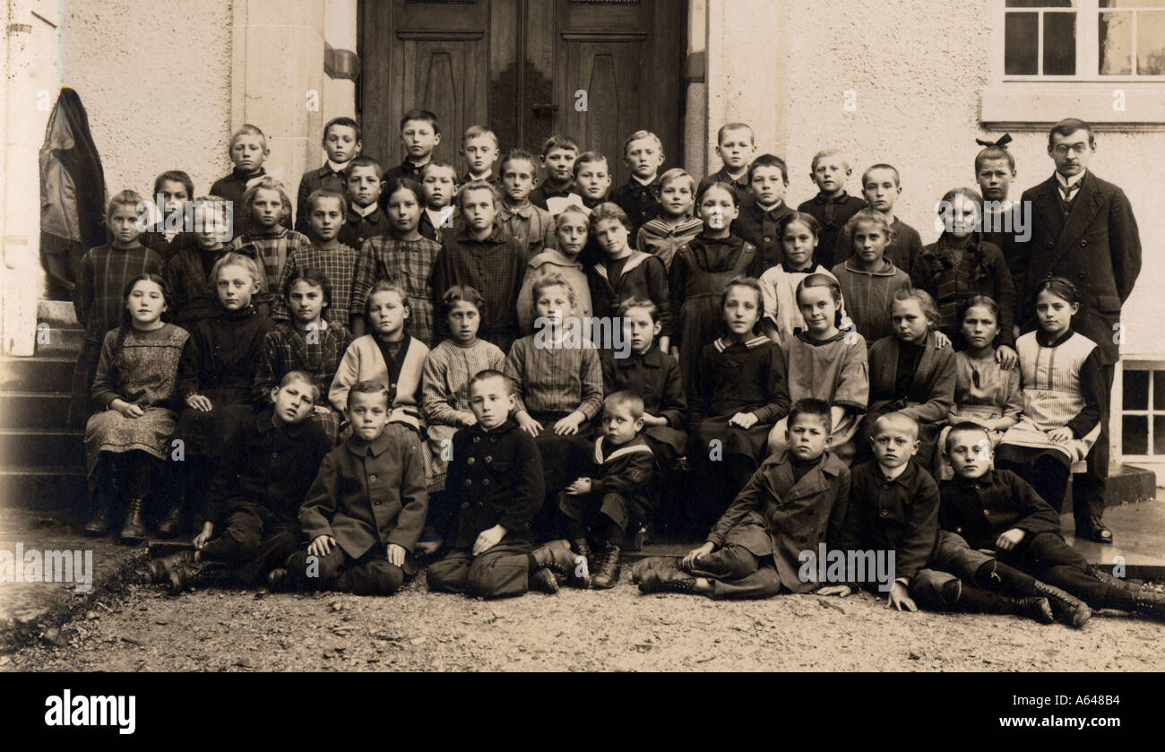 Imagen schoolclass histórico en el año 1900 los niños y niñas con el maestro enfrente de la escuela Foto de stock