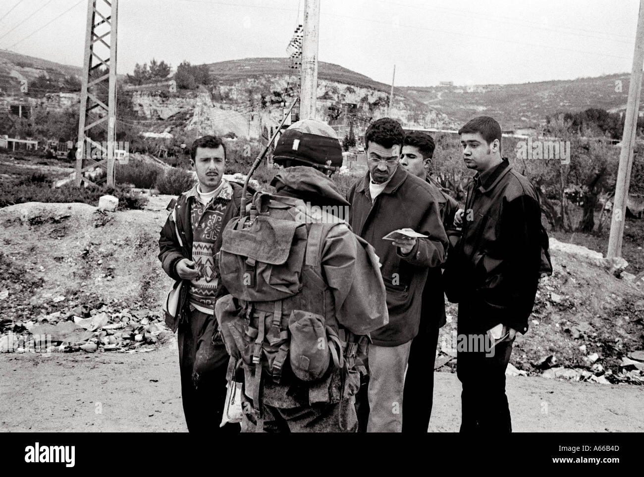 Soldado israelí la comprobación de los documentos de los jóvenes palestinos en Naplusa, Check Point West Bank Foto de stock