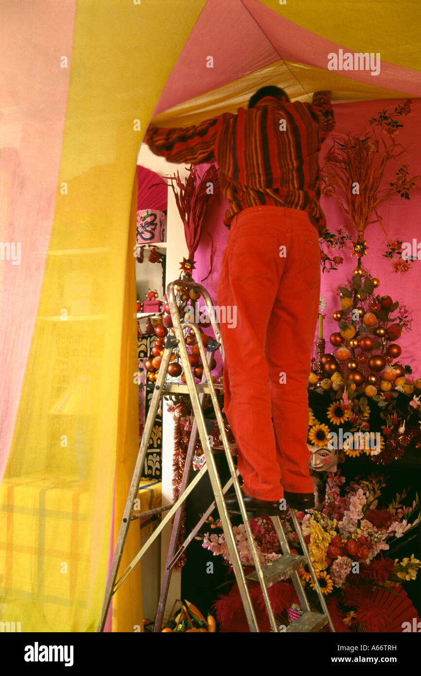 Hombre en escalera decorar la habitación para una fiesta Foto de stock