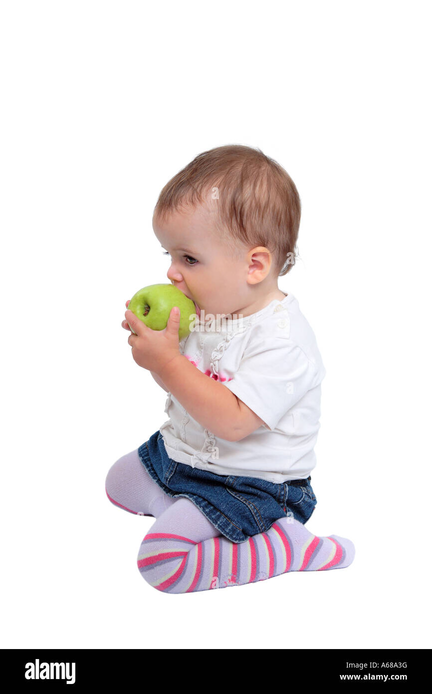 Foto aislados de jóvenes lindo bebé niña con pelo marrón de rodillas  comiendo manzanas verdes frescas o frutas vistiendo leotardos stripey  Fotografía de stock - Alamy
