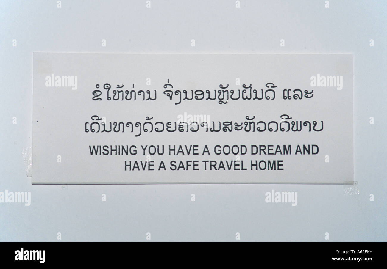 Signo simpático encima de la cama en una habitación de un hotel en Laos, lectura: deseando tener un buen sueño y tener un hogar seguro para viajar. Foto de stock