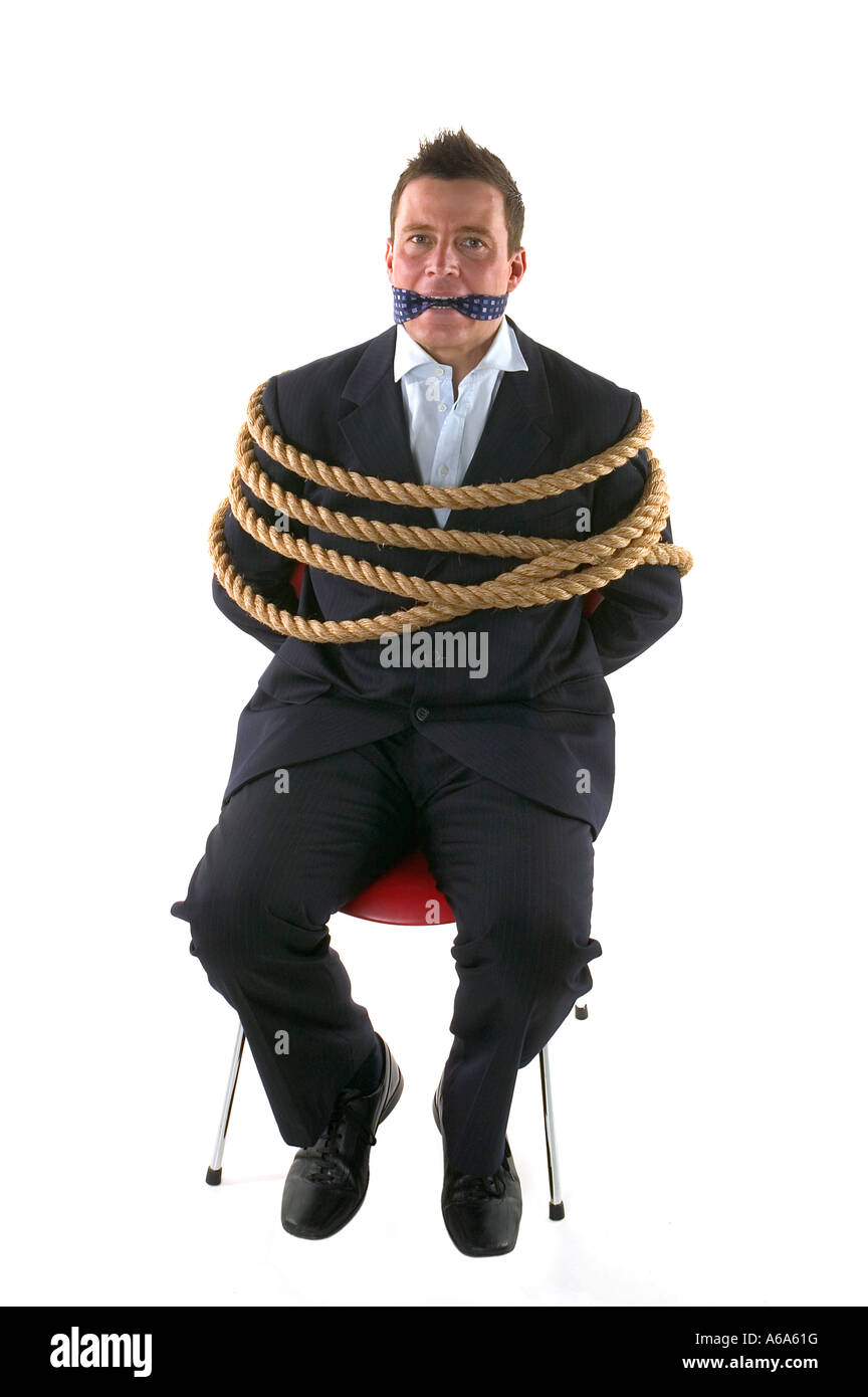 Empresario atada con cuerdas y amordazada con su propia corbata aislado sobre un fondo blanco. Foto de stock
