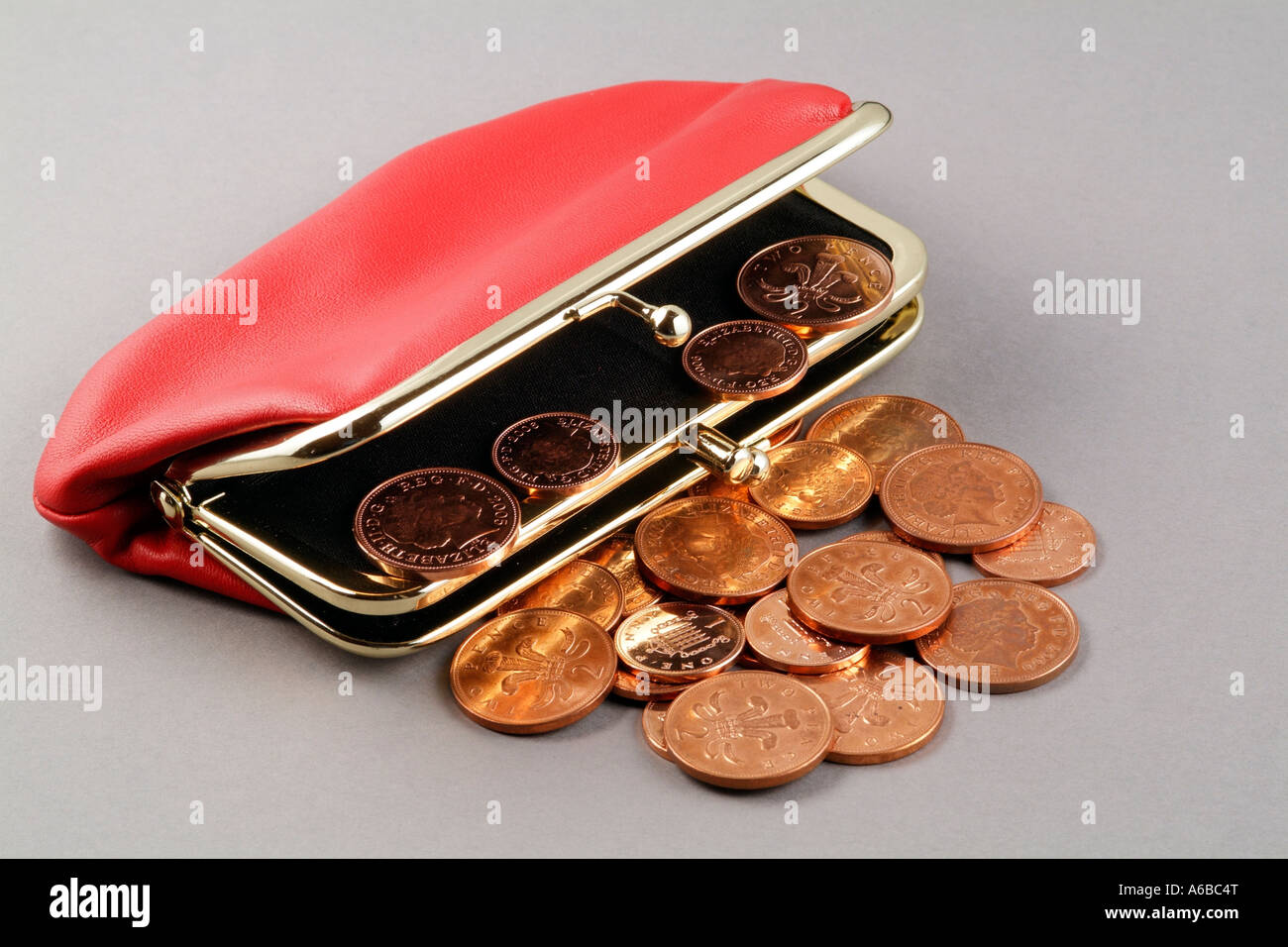 Dinero y un bolso de cuero rojo y Penny efectivo Twopence color cobre acuñación de monedas del Reino Unido el reino Foto de stock