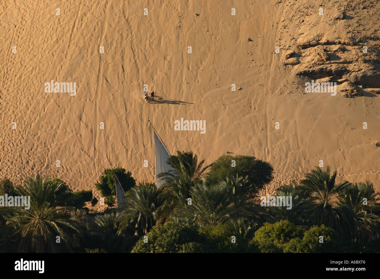 Dos personas recorren una duna hacia el nilo. Foto de stock