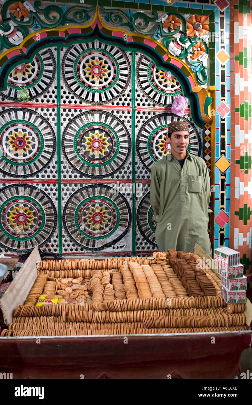 Joven vende galletas fuera mezquita Hassan Abdal mercado, Pakistán Foto de stock