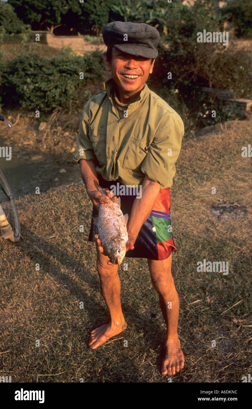 Hombre con los peces de su familia, un estanque de peces. Foto de stock