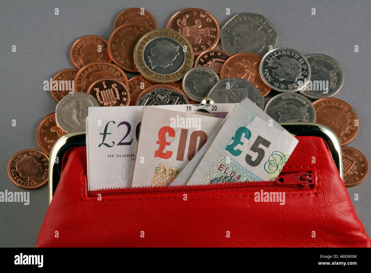 Dinero y un bolso de cuero rojo suelto efectivo cambiar de color cobre y plata monedas Notas acuñación de Reino Unido el reino Foto de stock