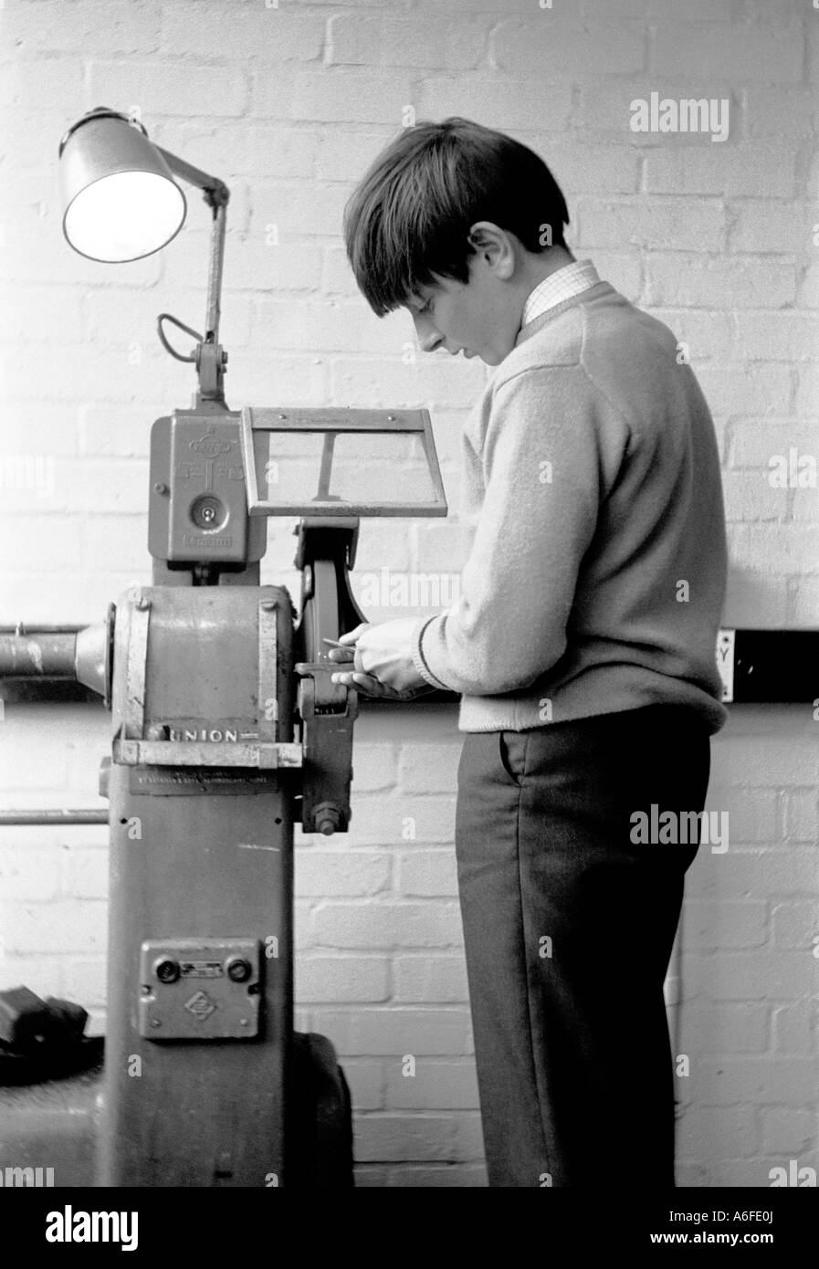 Muchacho alumno chapa de aprendizaje en la escuela. Londres 1966. Foto de stock