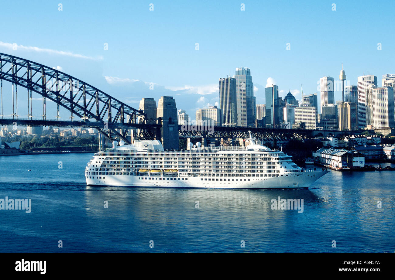 Sydney Harbour Un crucero hace su camino bajo el puente y pasando por la ciudad Australia Foto de stock