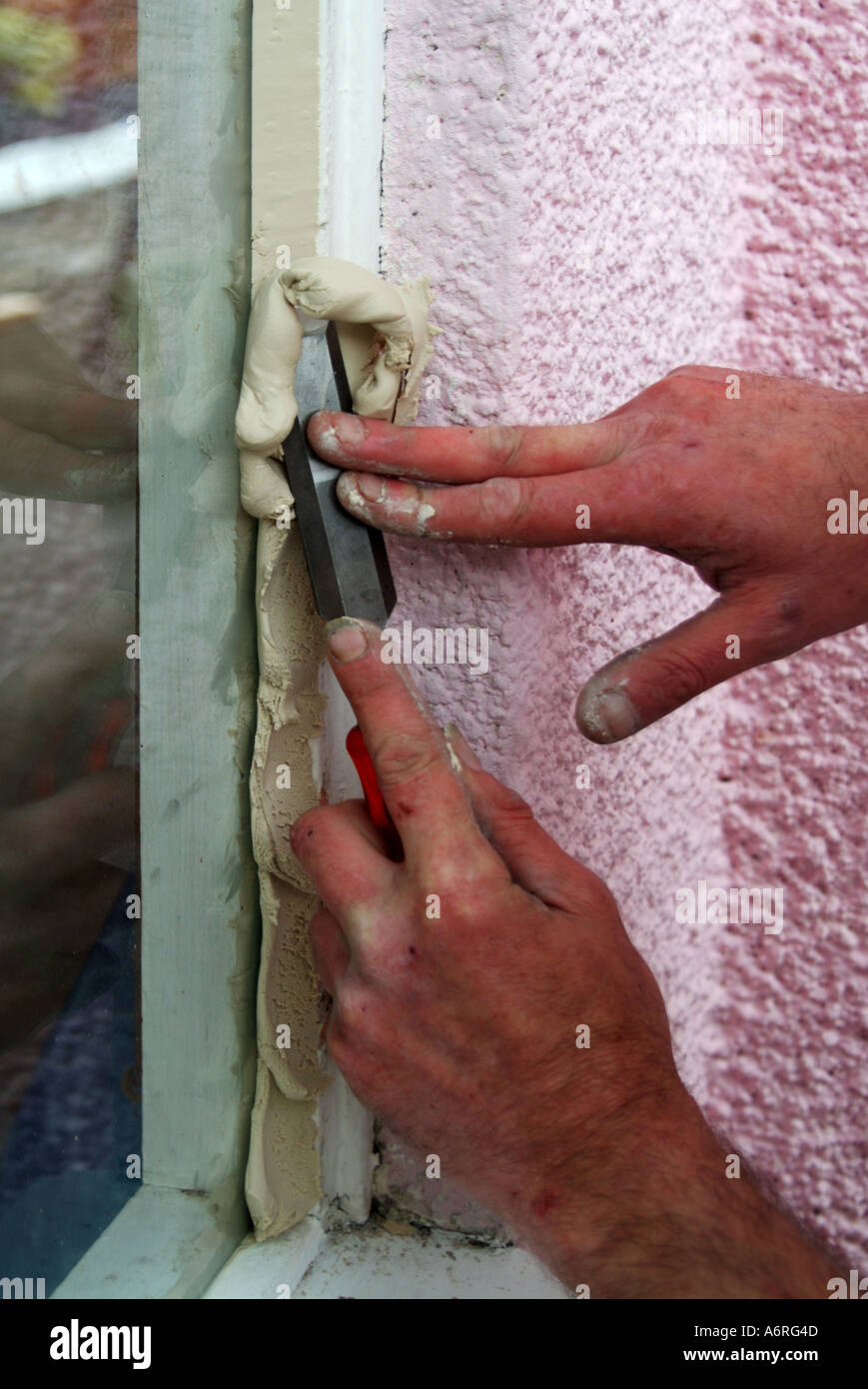 Masilla en la herramienta de espátula en manos masculinas closeup  reparación de madera con pasta