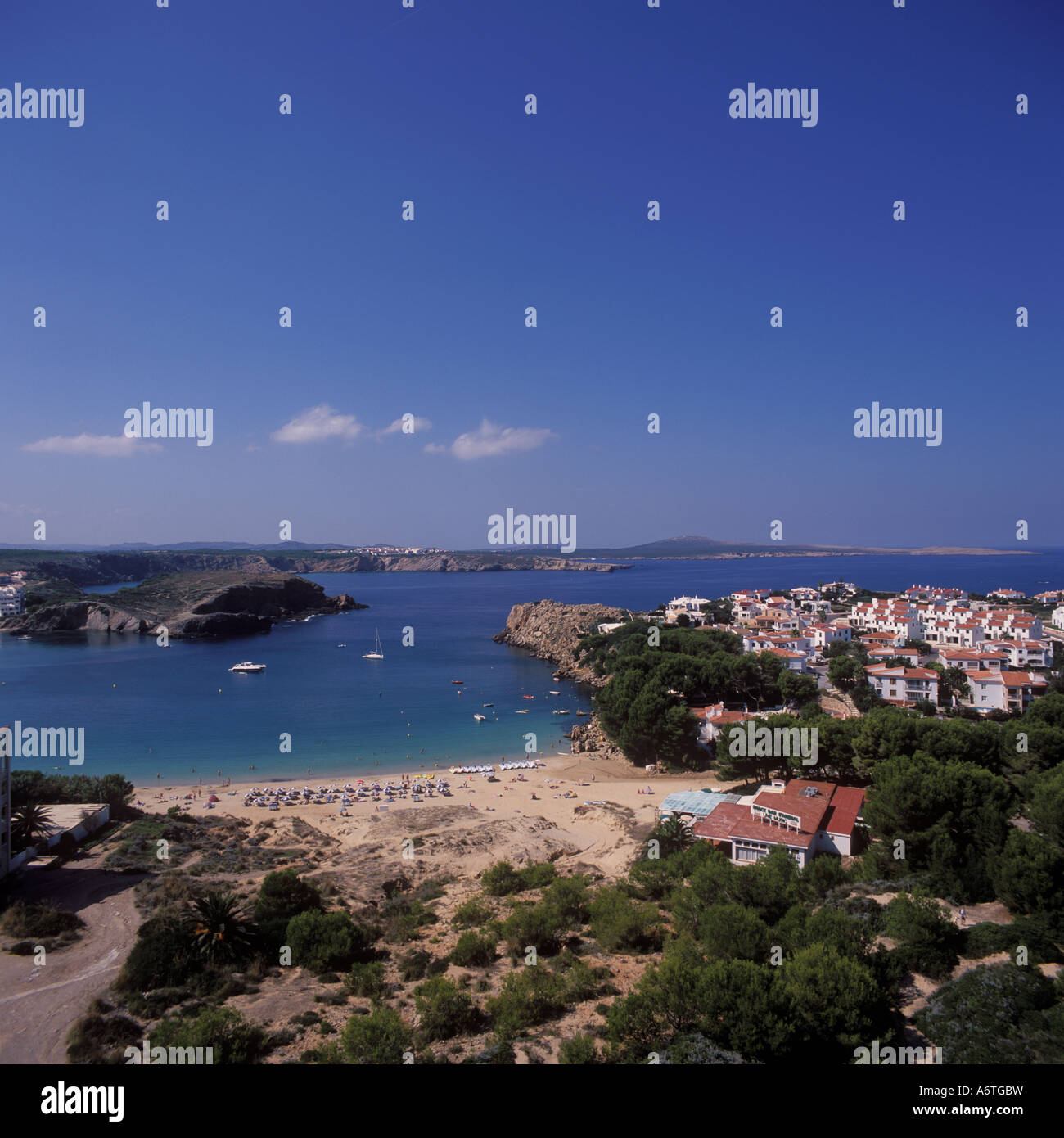 Vista aérea - sección de la playa y la bahía de recreo anclados + + urbanización - Arenal d'en Castell, costa norte de Menorca. Foto de stock