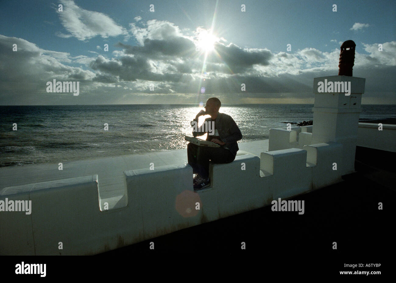 Norman Cook alias músico DJ Fat Boy Slim con un portátil en su Brighton Seafront home Foto de stock