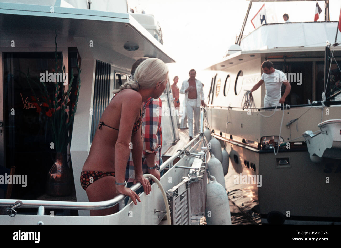 Chica en Bikini viendo barco atraque en St Tropez 1974 Foto de stock