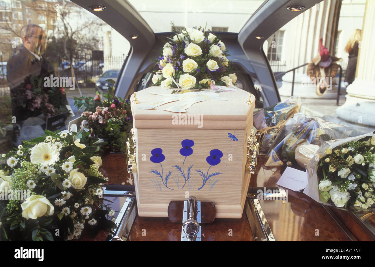 Un ataúd dentro de una carroza Pintada con flores azules Foto de stock